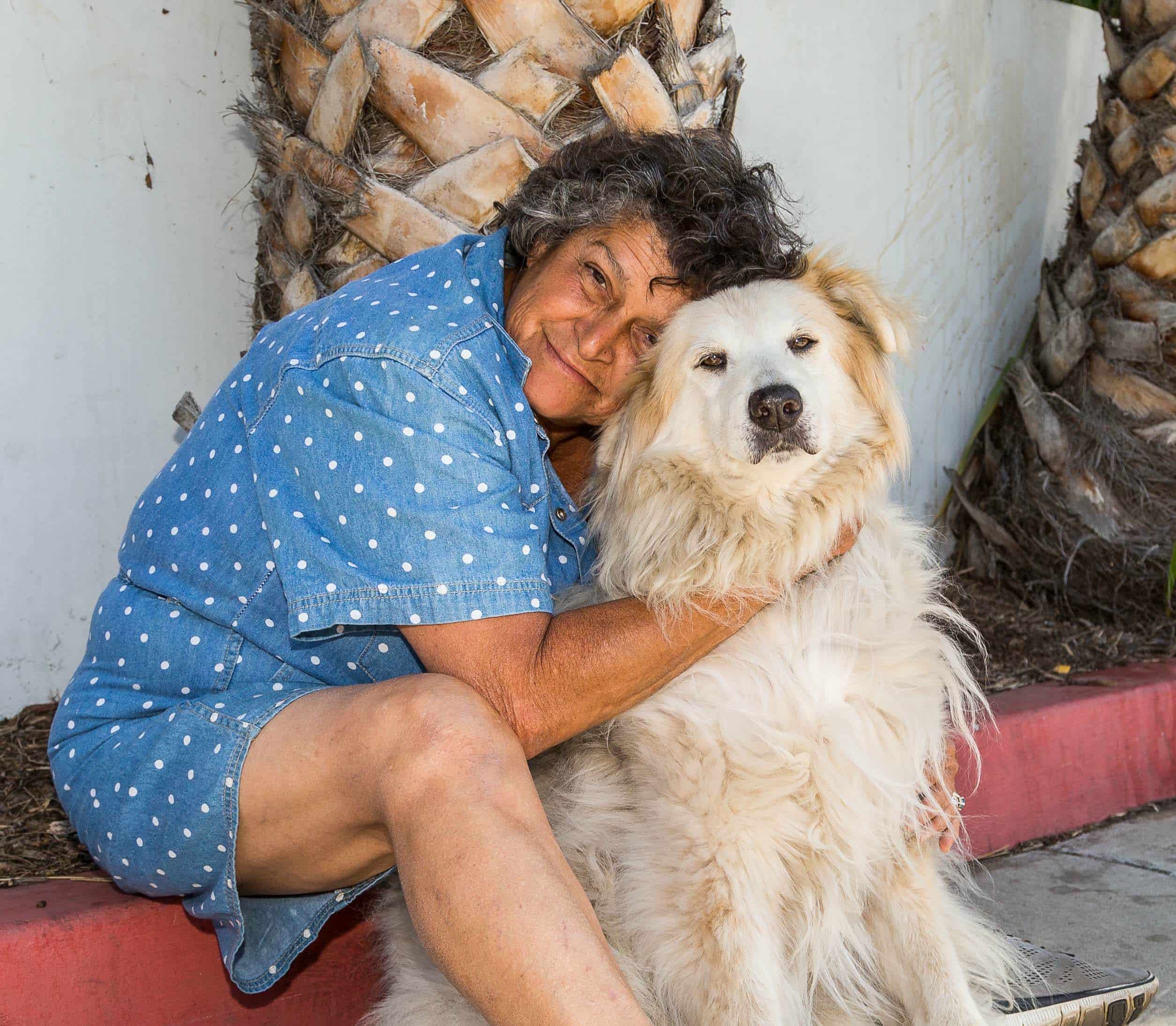 A lady wearing blue and her blond medium sized dog