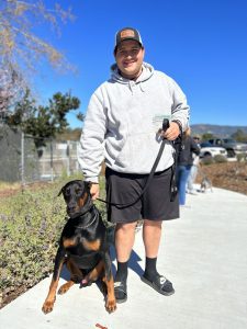 A man and his doberman pincher (mixed breed)