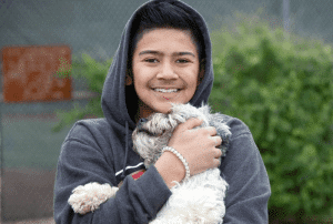A boy and his dog at a C.A.R.E.4Paws Mobile Pet Clinic
