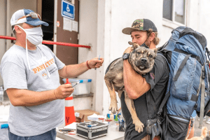 A homeless man with his dog getting a vaccine at a C.A.R.E.4Paws Mobile Pet Clinic