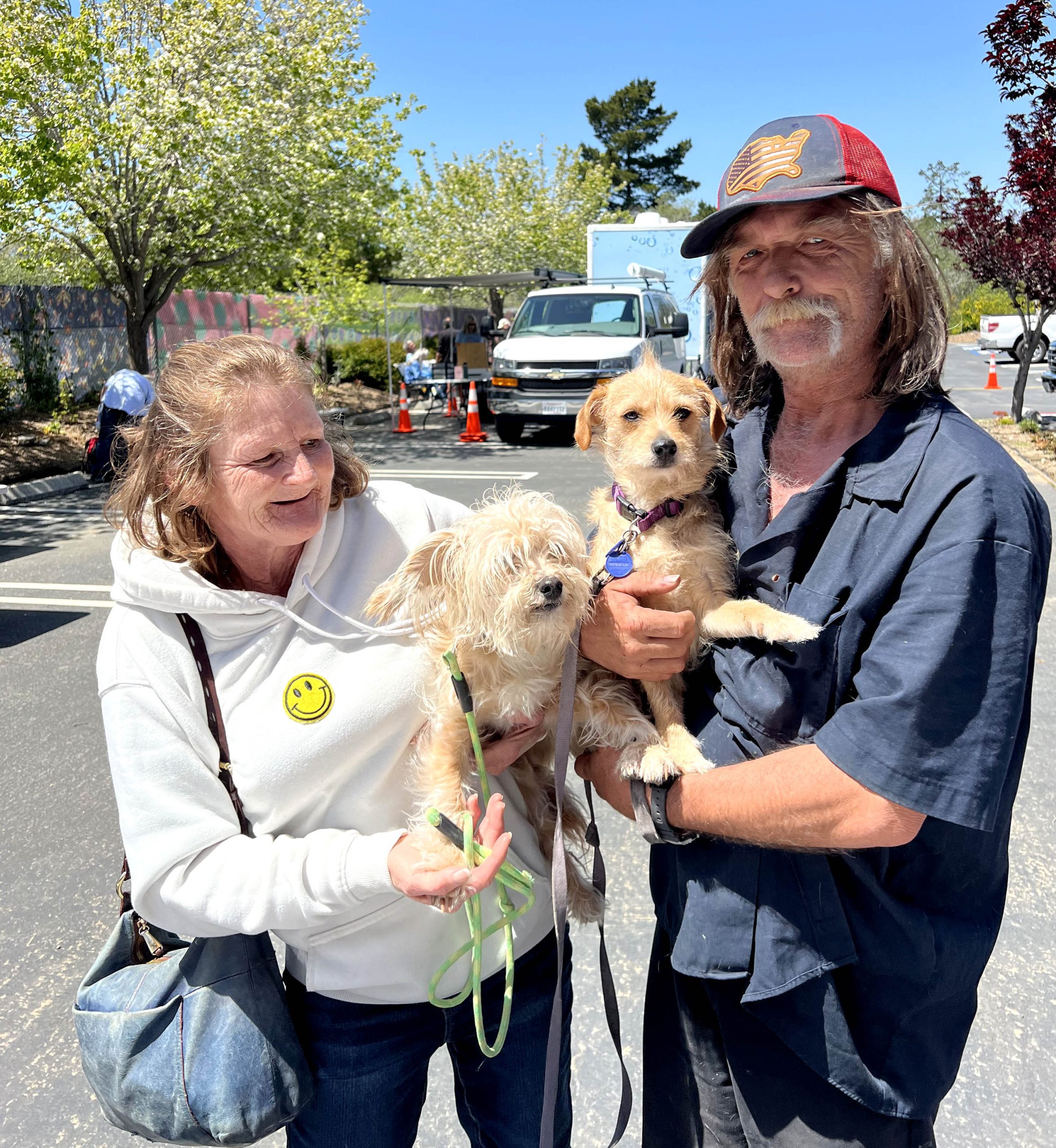 A homeless couple with their two dogs at a C.A.R.E.4Paws pet wellness clinic
