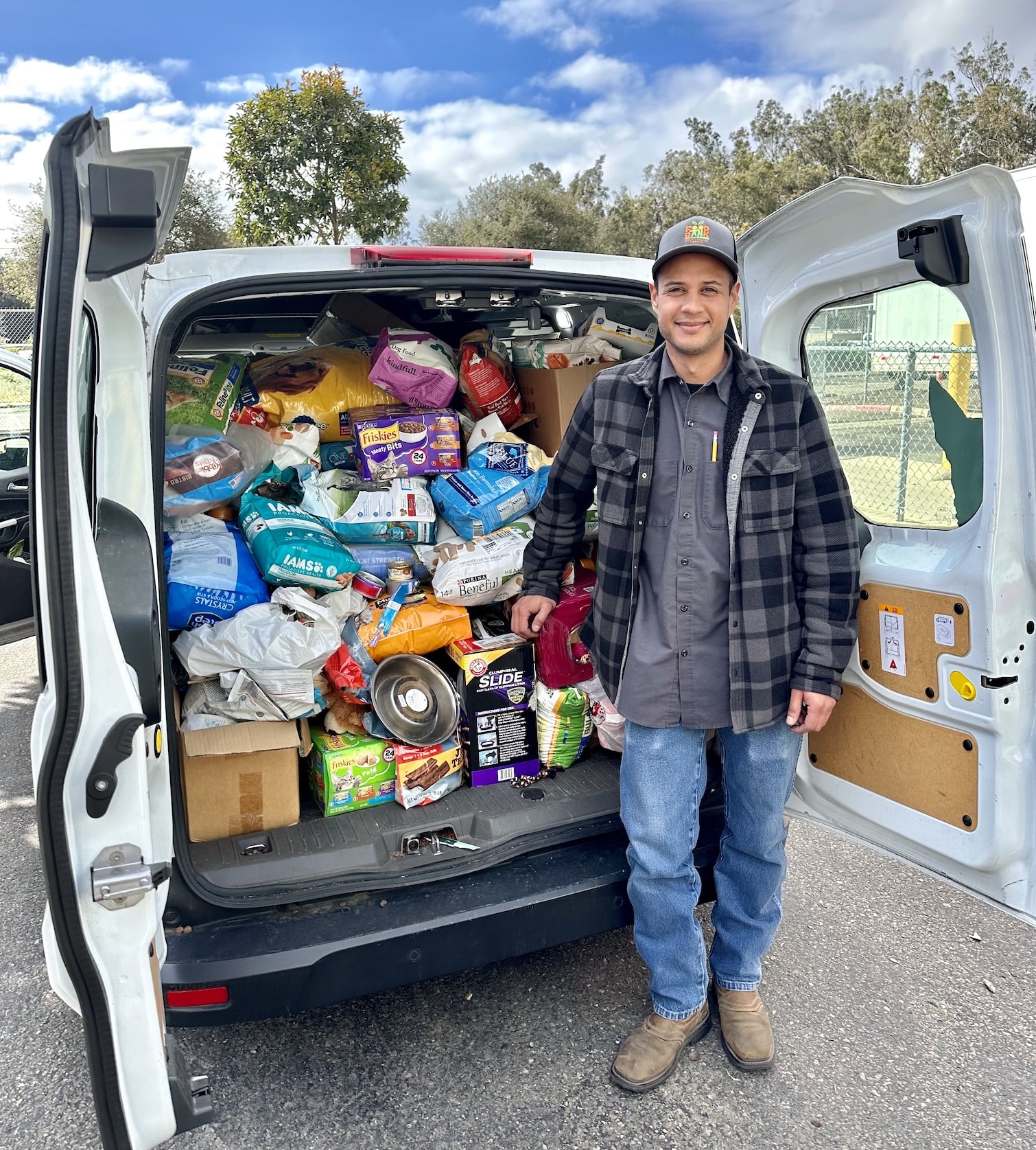Man with a C.A.R.E.4Paws van of food for pet families in need