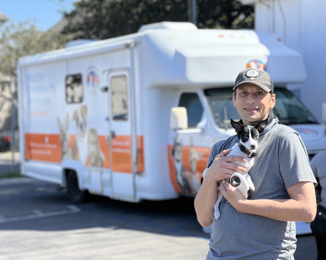 man holding a family pet at the C.A.R.E.4Paws mobile clinic