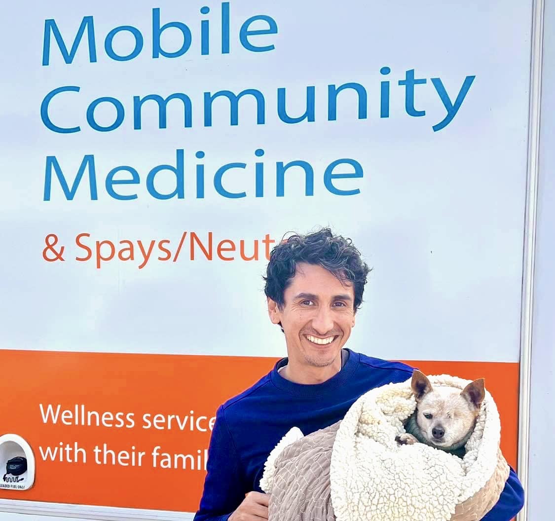 Man with his small dog in front of C.A.R.E.4Paws Mobile Clinic