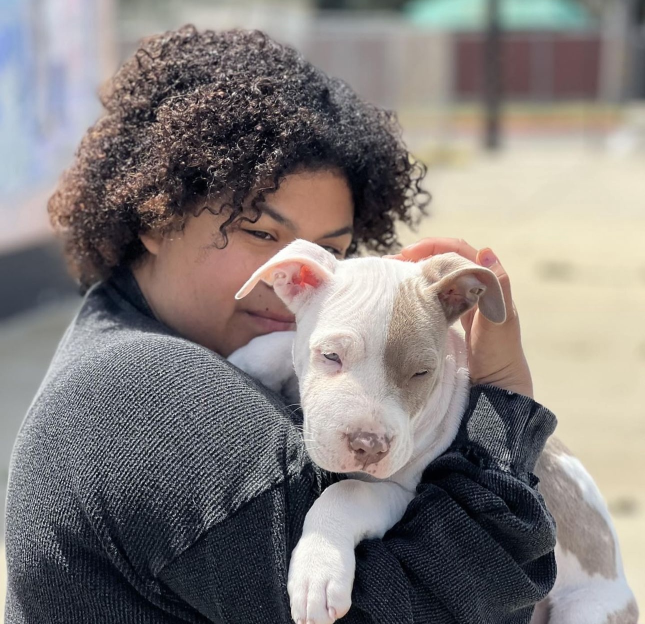 Young lady with her white and cream colored puppy