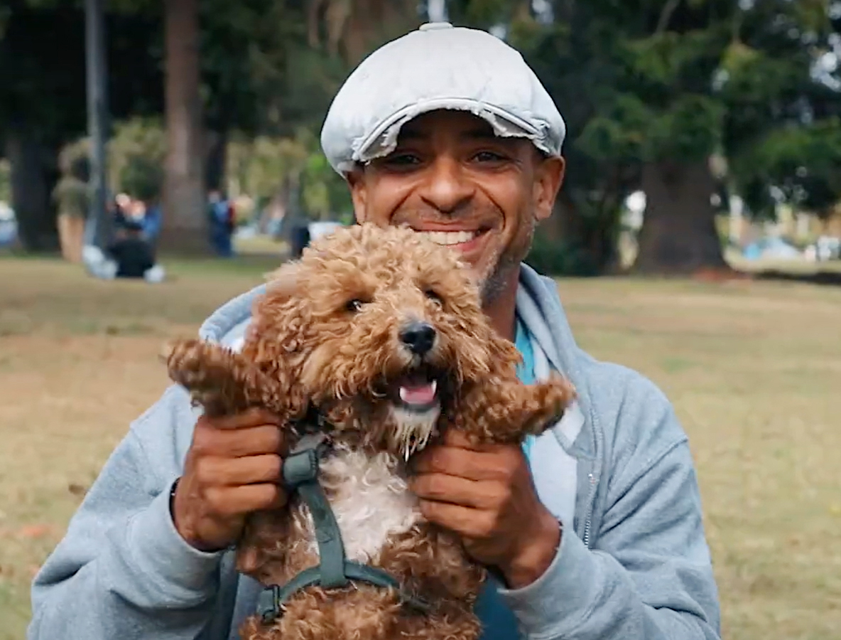 Man hold his large grey dog in the air for a picture