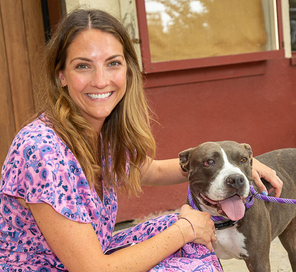 Erik Anda, C.A.R.E.4Paws Pet Wellness Clinic Coordinator, holding a white tabby
