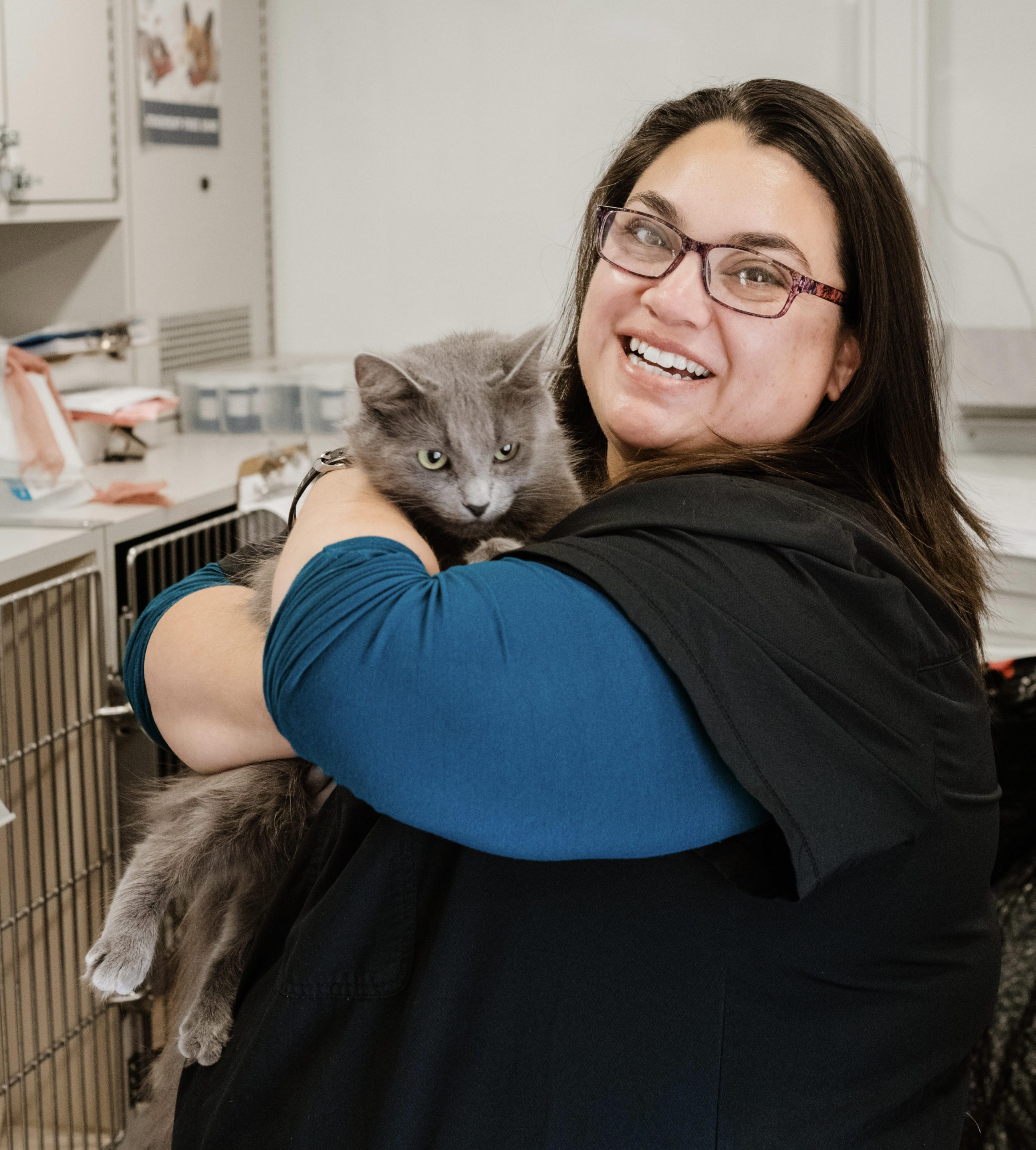 C.A.R.E.4Paws Lead Technician Ally Herrera holding a grey cat inside the mobile pet wellness clinic