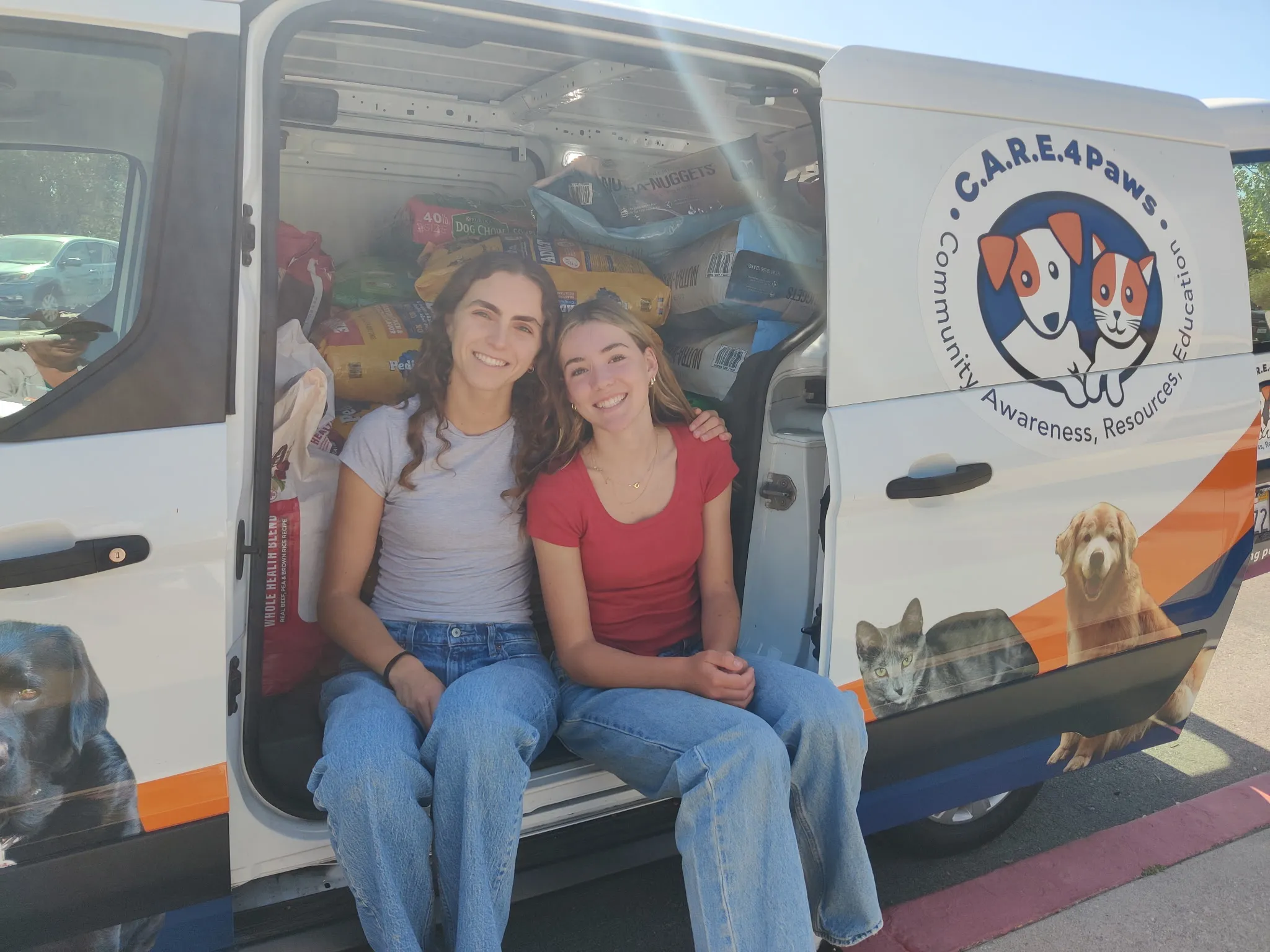 Ava in the news pet food drive with C.A.R.E.4Paws Ava with her friend sitting in the C.A.R.E.4Paws cargo van filled with pet food donations