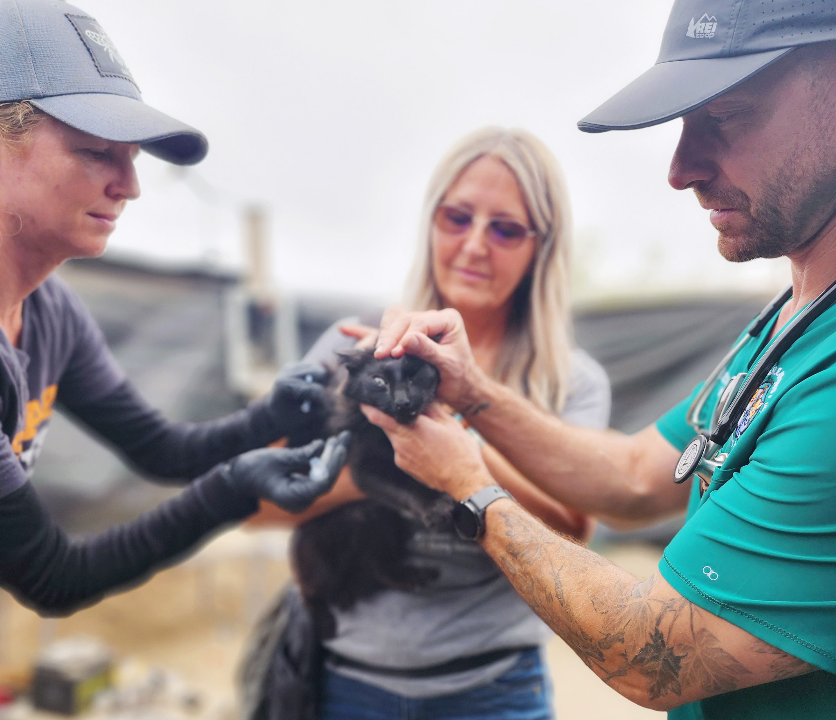 Santa Maria Riverbed C.A.R.E.4Paws volunteers, Christine LaBossiere and Claire Sheehy, with a black and brown rescue dog