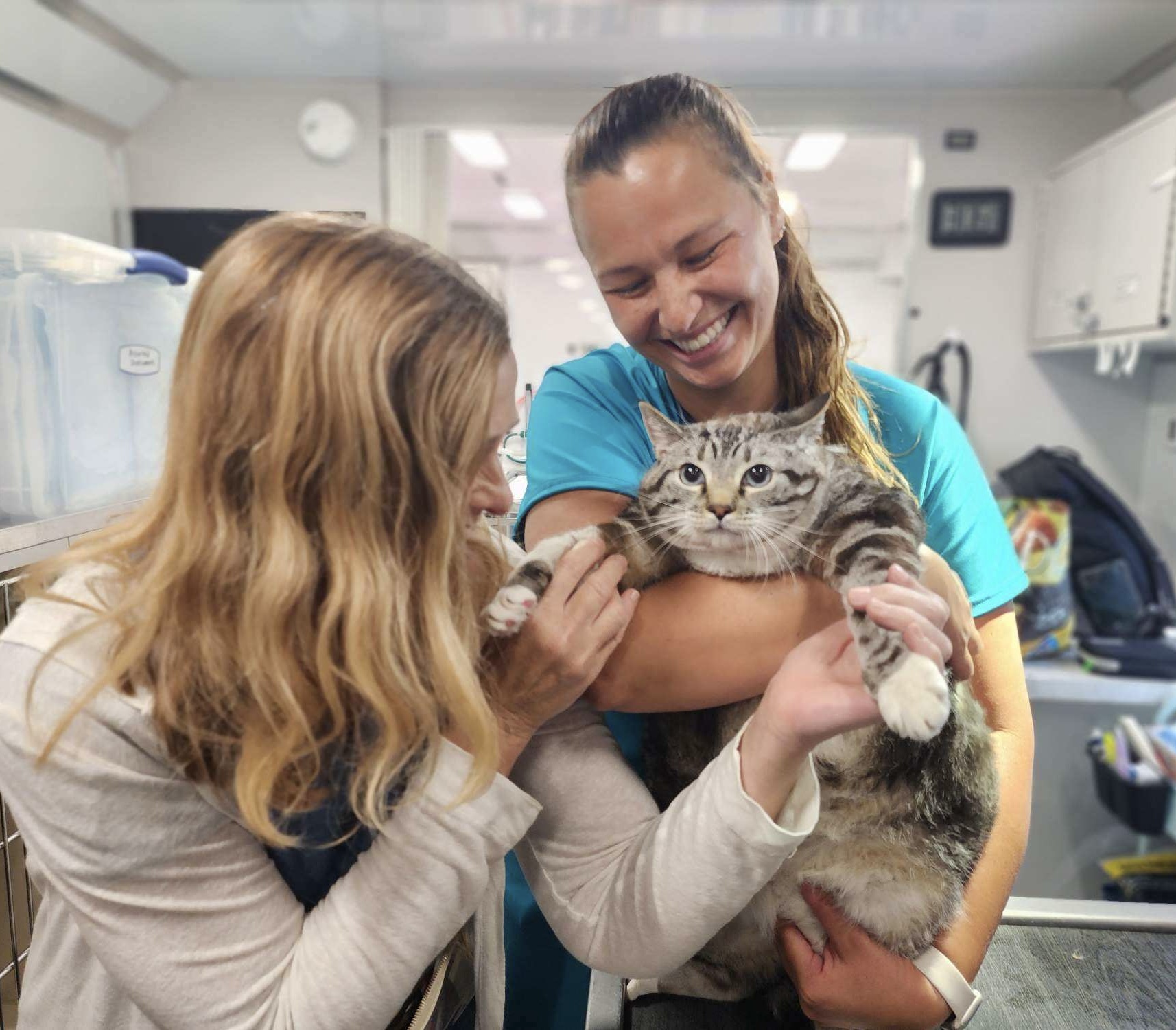 C.A.R.E.4Paws Courtesy Photo 2 Ava with her friend sitting in the C.A.R.E.4Paws cargo van filled with pet food donations