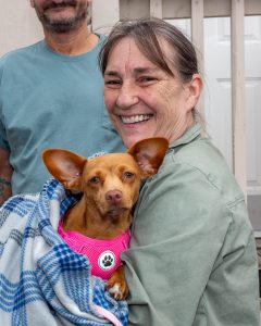 Lady and her small orange dog in pink collar