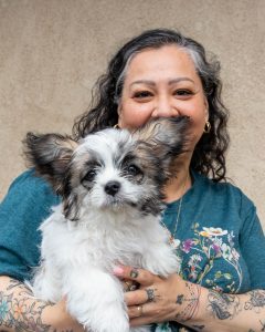 Lady with her cutie white dog with black and brown ears