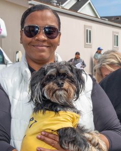 A lady with dark skin and her cute pooch staring at the camera