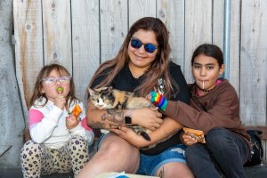 A pet family of four, one member is a calico cat