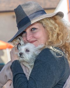 Close of lady with her white dog cradling and cuddling her dog