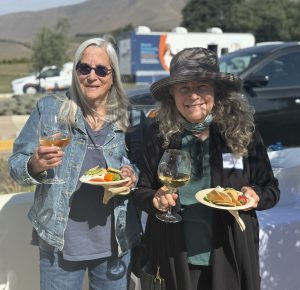 Two ladies posed with the C.A.R.E.4Paws' mobile clinic in the background