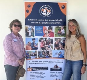 Libby posing in front of a C.A.R.E.4Paws infographic explaining our future Pet Refuge that we are currently fundraising to complete