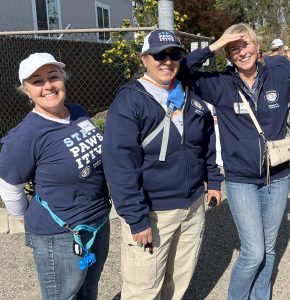Three volunteer wearing navy blue StayPawsitives shirts