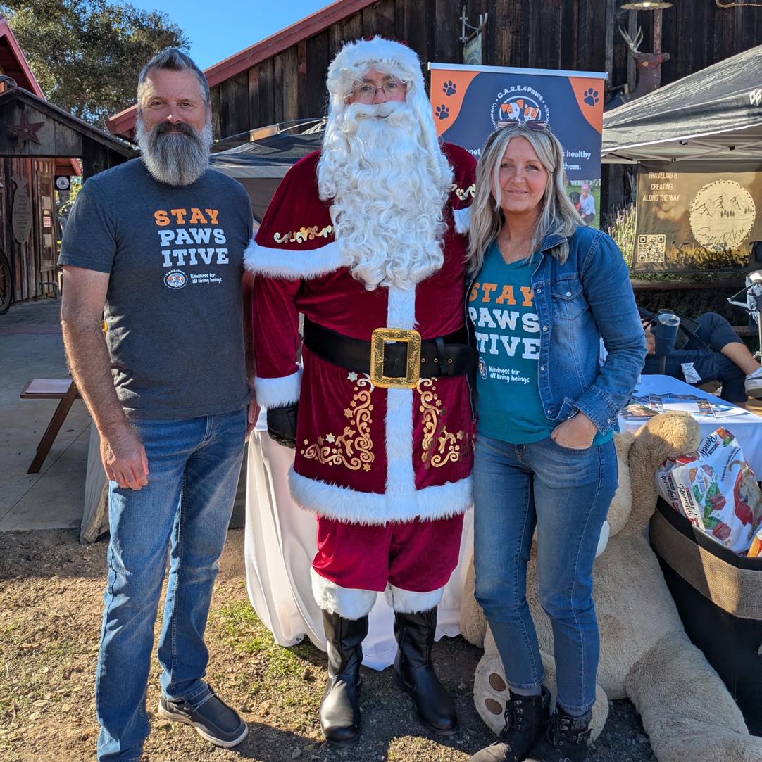 Staff member Libby Williams-Cabral with her husband posing with Santa Claus