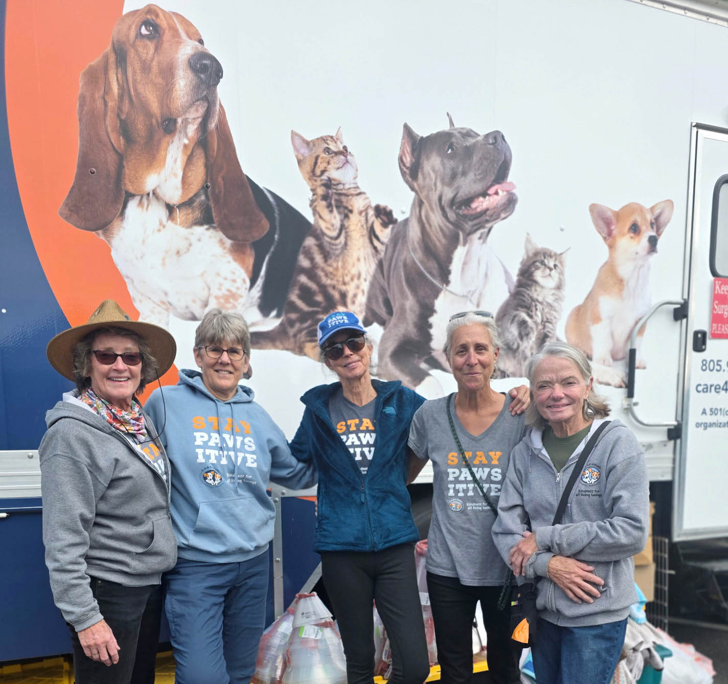 Five volunteers standing in front of C.A.R.E.4Paws mobile clinic