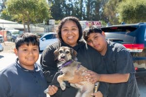 Family of three with a medium size dog at C.A.R.E.4Paws Mobile Pet Wellness Clinic