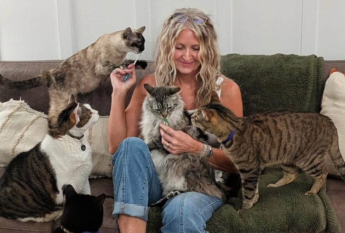 Libby Cabral with Animals In Need Fund with five of her foster cats who are receiving treats