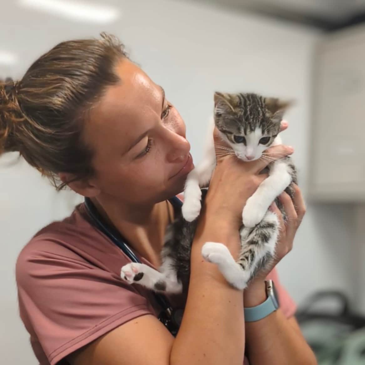 Dr. Meighan Gomes admiring a small kitten while securely cradling it